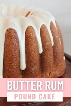 a bundt cake with white icing sitting on top of a wooden platter