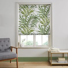 a living room with a chair and window covered in green leafy blinds on the windowsill