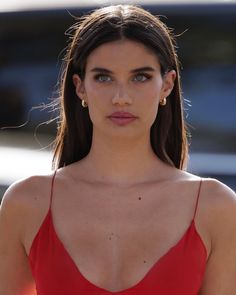 a close up of a person wearing a red dress