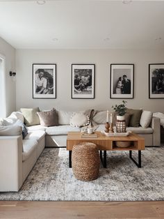 a living room filled with furniture and pictures hanging on the wall above it's coffee table