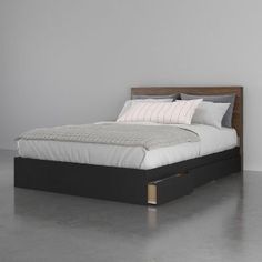 a bed with two drawers underneath it in the middle of a floored room,