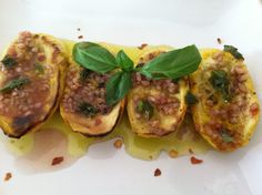 three stuffed acorns on a plate with sauce and green leafy garnish