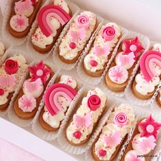 a box filled with lots of decorated cookies in pink and white icing on top of each other