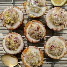 several lemon muffins with icing on a cooling rack next to a spoon