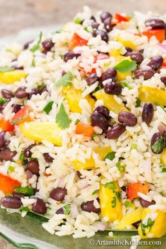 rice and beans are mixed together in a dish on a glass plate, ready to be eaten