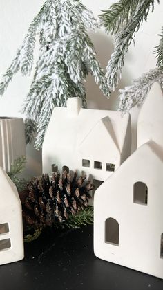 some white houses and pine cones on a table