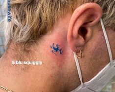 a man with a small tattoo on his ear