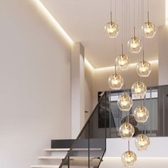 a modern chandelier hanging from the ceiling in a room with stairs and windows