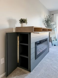 an empty room with a fireplace and shelves