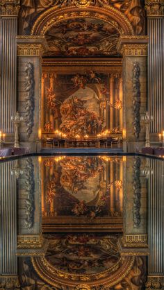 an ornately decorated room with candles and mirrors on the wall, reflecting it's reflection in the water