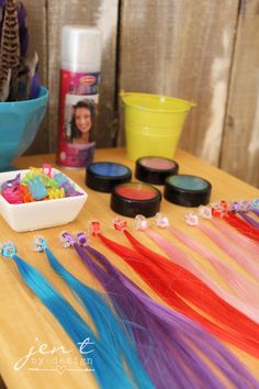 there are many different colors of hair on the table next to some bowls and containers