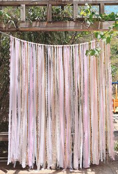 pink and white streamers hanging from a wooden structure