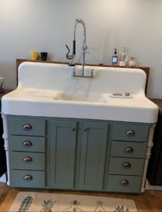 a kitchen sink sitting under a faucet next to a counter top with drawers