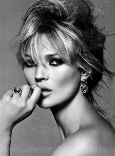 a black and white photo of a woman posing with her hand on her chin, looking at the camera