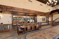 a dining room table with chairs and a horse statue on the wall in front of it