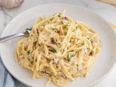 a white plate topped with pasta covered in sauce