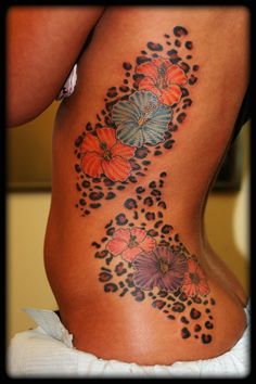 a woman's back with flowers and butterflies on it