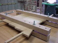 two pieces of wood sitting on top of a wooden workbench in a shop