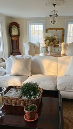 a living room filled with furniture and a clock on the wall next to a window