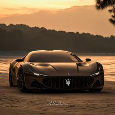 a brown sports car parked on top of a sandy beach next to the ocean at sunset