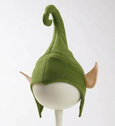 a green elf hat on top of a white stick