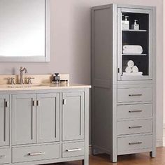 a bathroom with two sinks and a large mirror above it, in front of a wall mounted cabinet