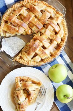 an apple pie with one slice missing from it and another piece on the plate next to it