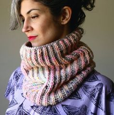 a woman wearing a multicolored knit scarf