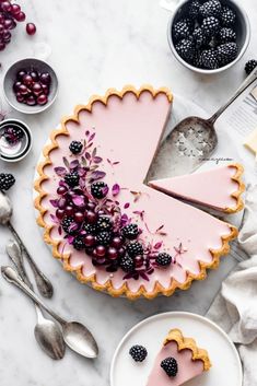 there is a pie with berries on the top and other desserts around it, including raspberries