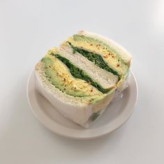 a sandwich on a white plate sitting on a table