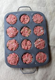 a muffin tin filled with mini hamburger patties