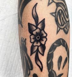 a close up of a person's leg with tattoos on it and an image of a flower