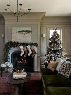 a living room filled with furniture and a christmas tree in front of a fire place