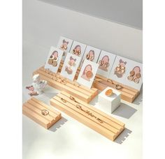 there are many cards and pictures on the wooden stand that is set up for display