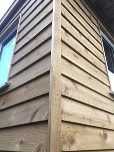 the side of a wooden house with windows and sidings on it's sides