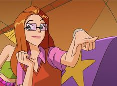 a woman with glasses is pointing to the stars on her shirt and holding something in her hand