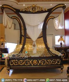 an ornate bed with white drapes and gold accents