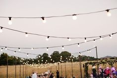 an outdoor party with string lights and tables