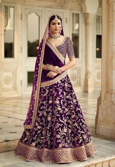 a woman in a purple and gold lehenga