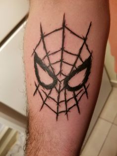 a spider - man tattoo on the arm with barbed wire around it's eyes