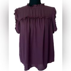 A Maroon Purple Short Sleeve Blouse From Who Wore What. Ruffle Mock Neck With Button Closure In Back. Ruffle Puff Sleeves. Size Small Great Condition, Never Worn Chic Purple Puff Sleeve Blouse, Purple Tops With Ruffles And Ruffled Collar, Purple Ruffled Collar Blouse With Ruffles, Purple Ruffle Puff Sleeve Tops, Purple Puff Sleeve Top With Ruffles, Dark Purple Blouse, Maroon Purple, Purple Blouse, Purple Shorts