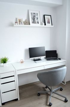 a white desk with a laptop computer on top of it next to a shelf filled with pictures