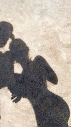 the shadow of two people standing next to each other