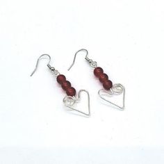 Heart earrings, handcrafted in silver wire with red glass beads. Cheap Red Wire Wrapped Earrings, Cheap Red Earrings With Ear Wire, Cheap Heart Beads Earrings As Gift, Cheap Beaded Earrings With Heart Beads As A Gift, Cheap Beaded Heart Earrings For Valentine's Day, Cheap Beaded Dangle Heart Earrings, Cheap Heart Beads Earrings, Cheap Red Beaded Earrings With Ear Wire, Green Tassel Earrings