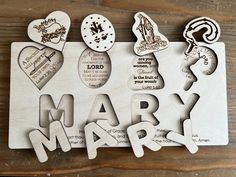 the word mary surrounded by wooden cutouts on a wood surface with hearts and other items