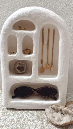 a white display case with sunglasses and other accessories