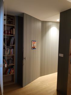 an empty room with bookshelves and a book shelf in the corner on the wall