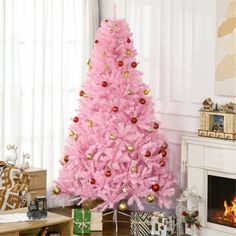 a pink christmas tree in a living room with presents on the floor and a fire place