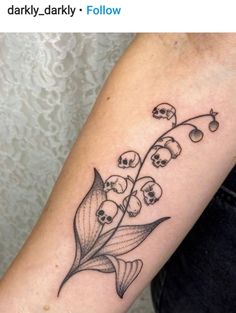 a black and white photo of a lily of the valley tattoo on someone's arm