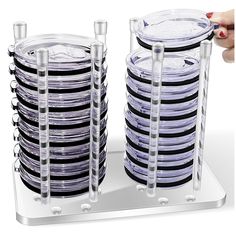 a stack of black and white plates sitting on top of a metal plate stand next to each other